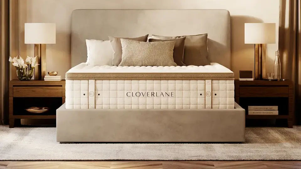 Cloverlane Hybrid Mattress placed on a beige fabric bedframe in a stylish bedroom